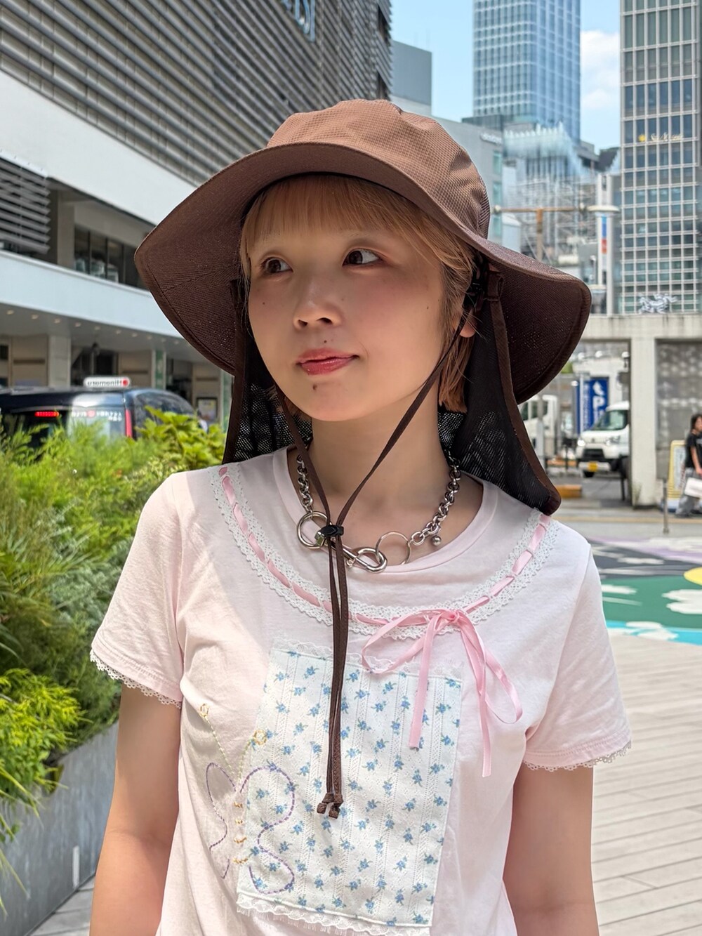 ブラウン系のハットを着用したレディースの夏コーディネートの2枚目の写真