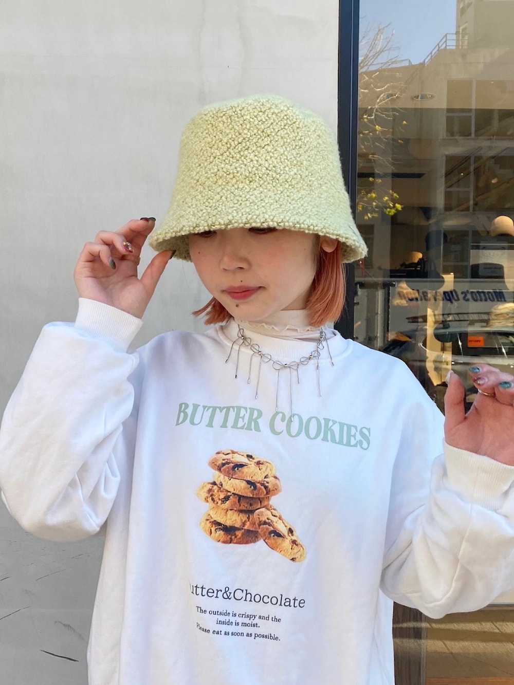 ホワイト系のスウェット、グレー系のスラックス、ホワイト系のスニーカーを着用したレディースの冬コーディネートの2枚目の写真