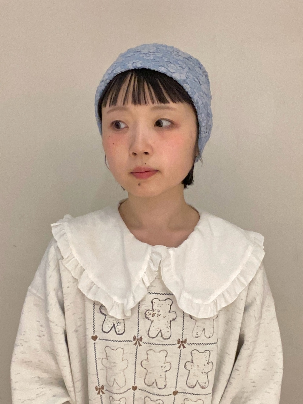 ブルー系のニットキャップ/ビーニーを着用したレディースの春コーディネートの2枚目の写真