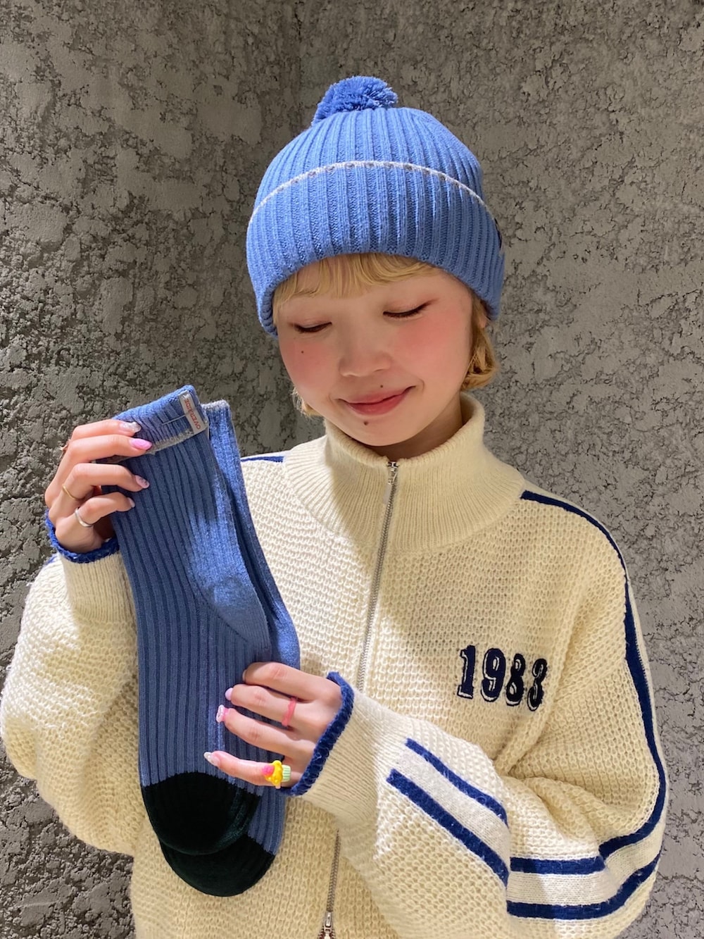 ブルー系のニットキャップ/ビーニーを着用したレディースの冬コーディネートの2枚目の写真