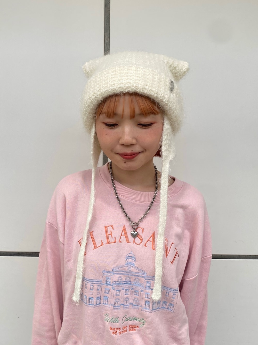 ピンク系のTシャツ/カットソー、ブルー系のデニムパンツ、ホワイト系のニットキャップ/ビーニーを着用したレディースの秋コーディネートの2枚目の写真