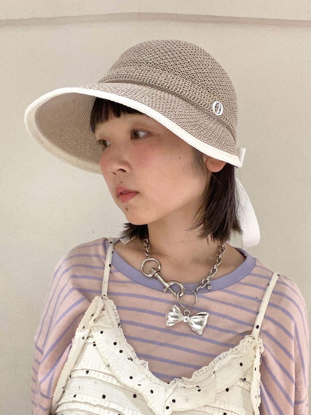 ベージュ系のキャップを着用したレディースの夏コーディネートの2枚目の写真