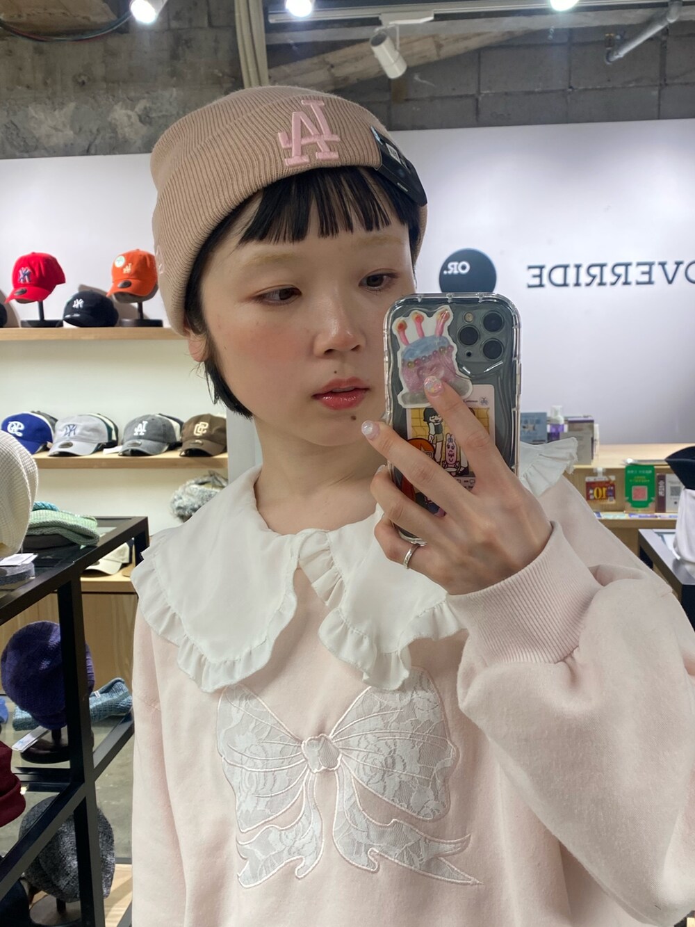 ピンク系のニットキャップ/ビーニーを着用したレディースの冬コーディネートの2枚目の写真