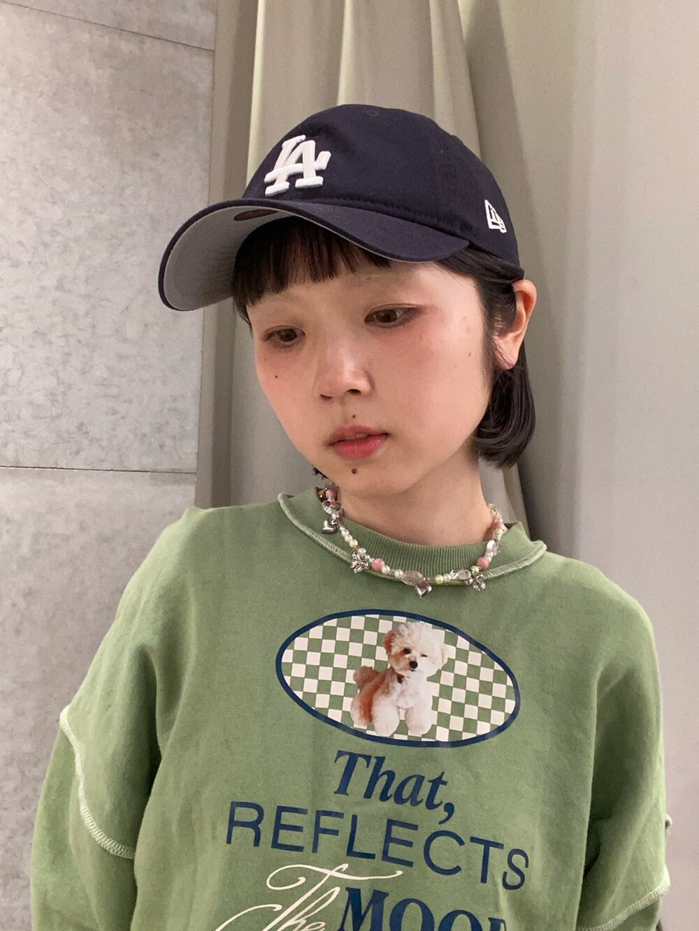 ブルー系のキャップを着用したレディースの春コーディネートの2枚目の写真