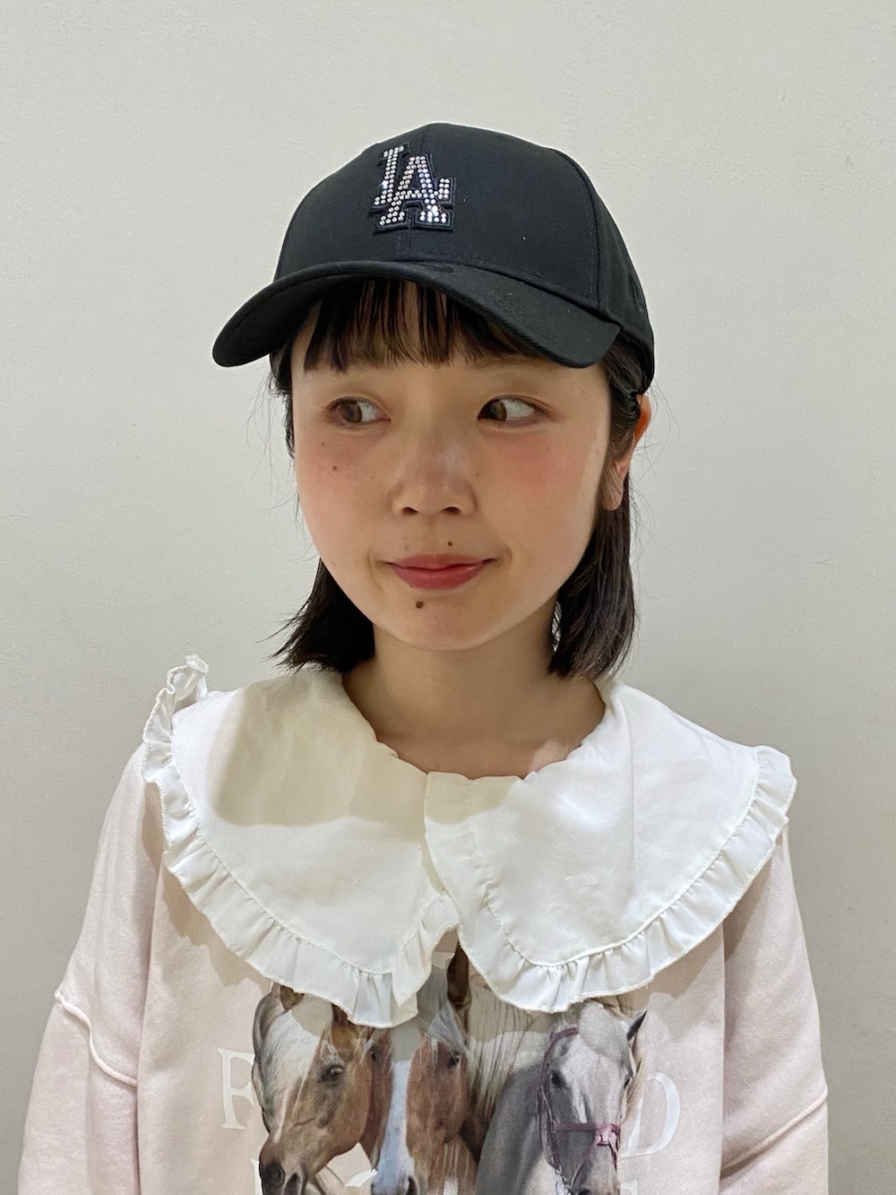 ブラック系のキャップを着用したレディースの春コーディネートの2枚目の写真