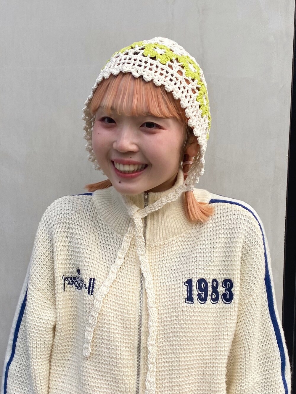 ホワイト系のニット/セーター、ピンク系のワンピース、ピンク系のスニーカーを着用したレディースの春コーディネートの2枚目の写真