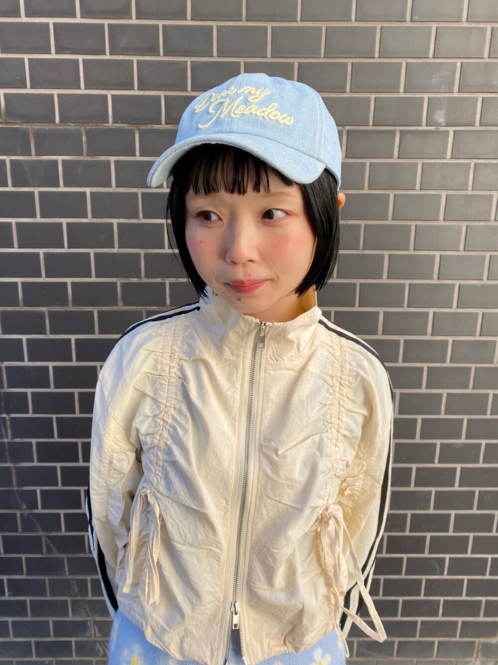 ブルー系のキャップを着用したレディースの冬コーディネートの2枚目の写真