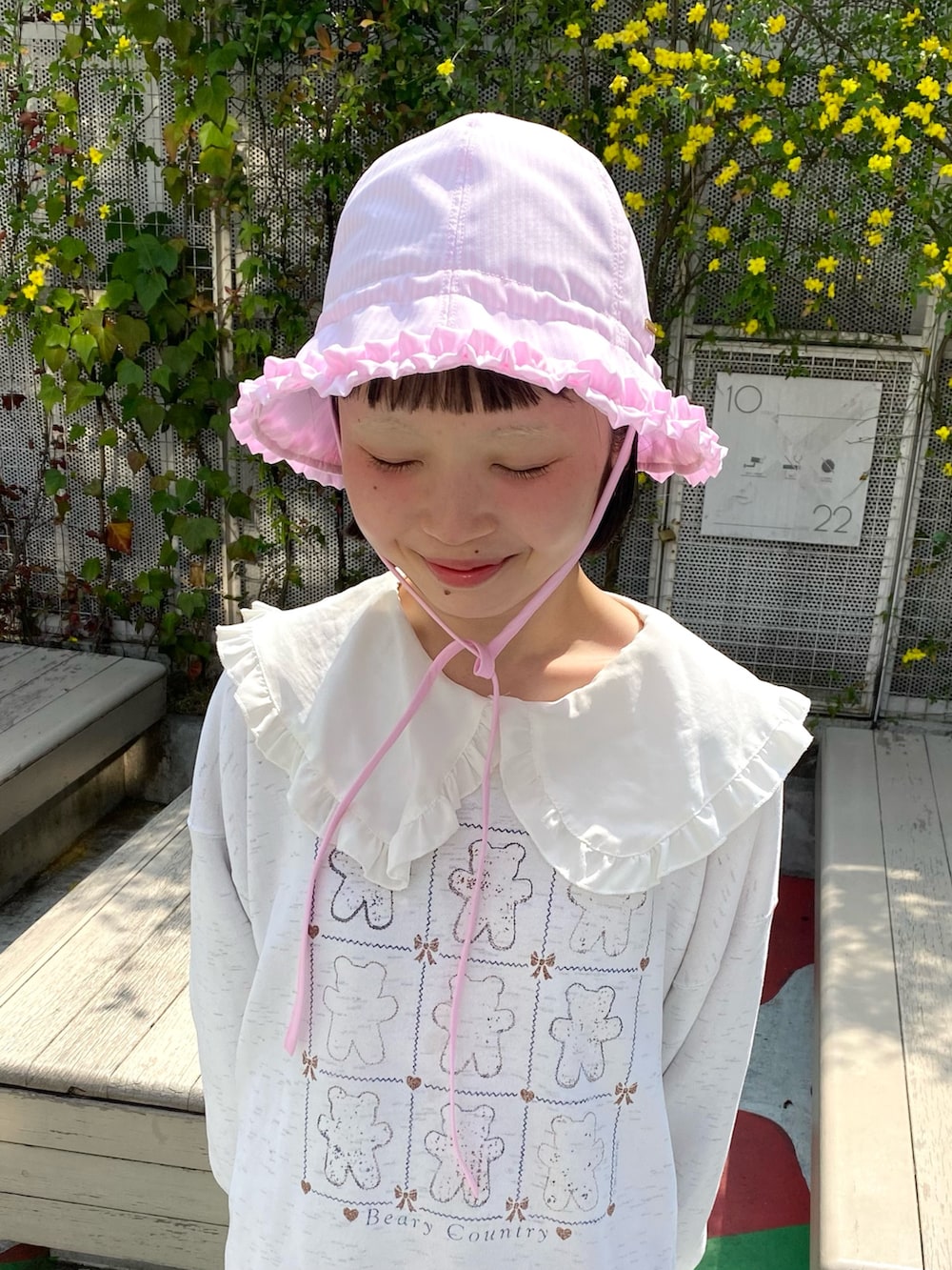 ピンク系のハットを着用したレディースの春コーディネートの2枚目の写真