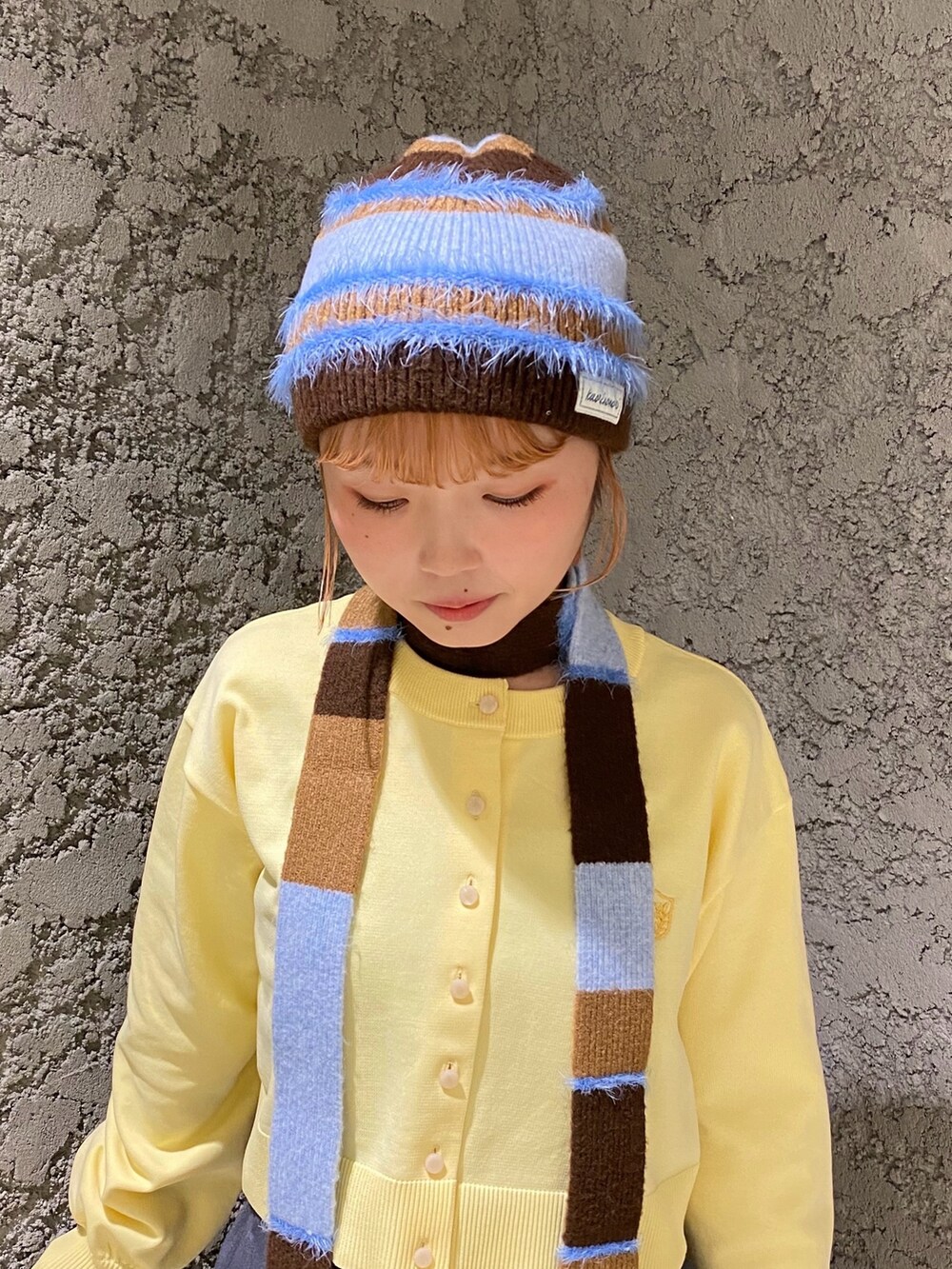 ブラウン系のニットキャップ/ビーニーを着用したレディースの秋コーディネートの2枚目の写真
