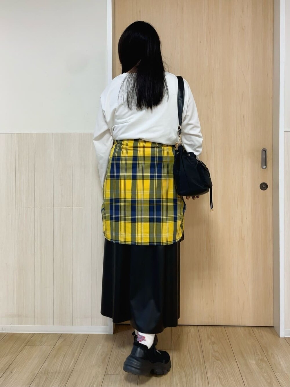 ホワイト系のTシャツ/カットソー、イエロー系のシャツ/ブラウス、ブラック系のスカートを着用したレディースの秋コーディネートの3枚目の写真