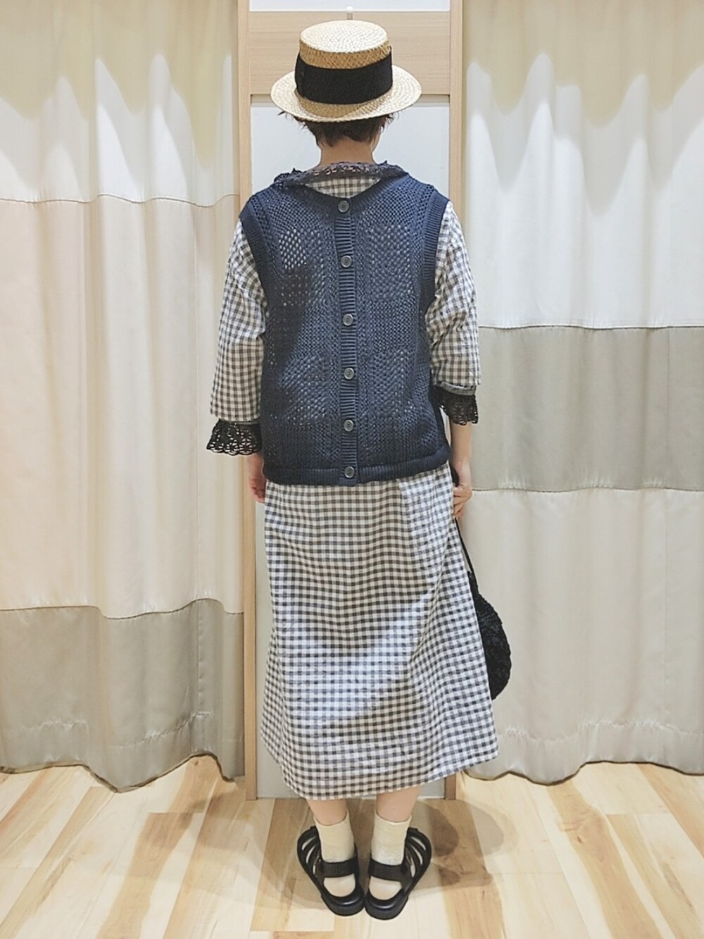 グレー系のベスト、グレー系のワンピース、ブラック系のシャツ/ブラウスを着用したレディースの春コーディネートの4枚目の写真