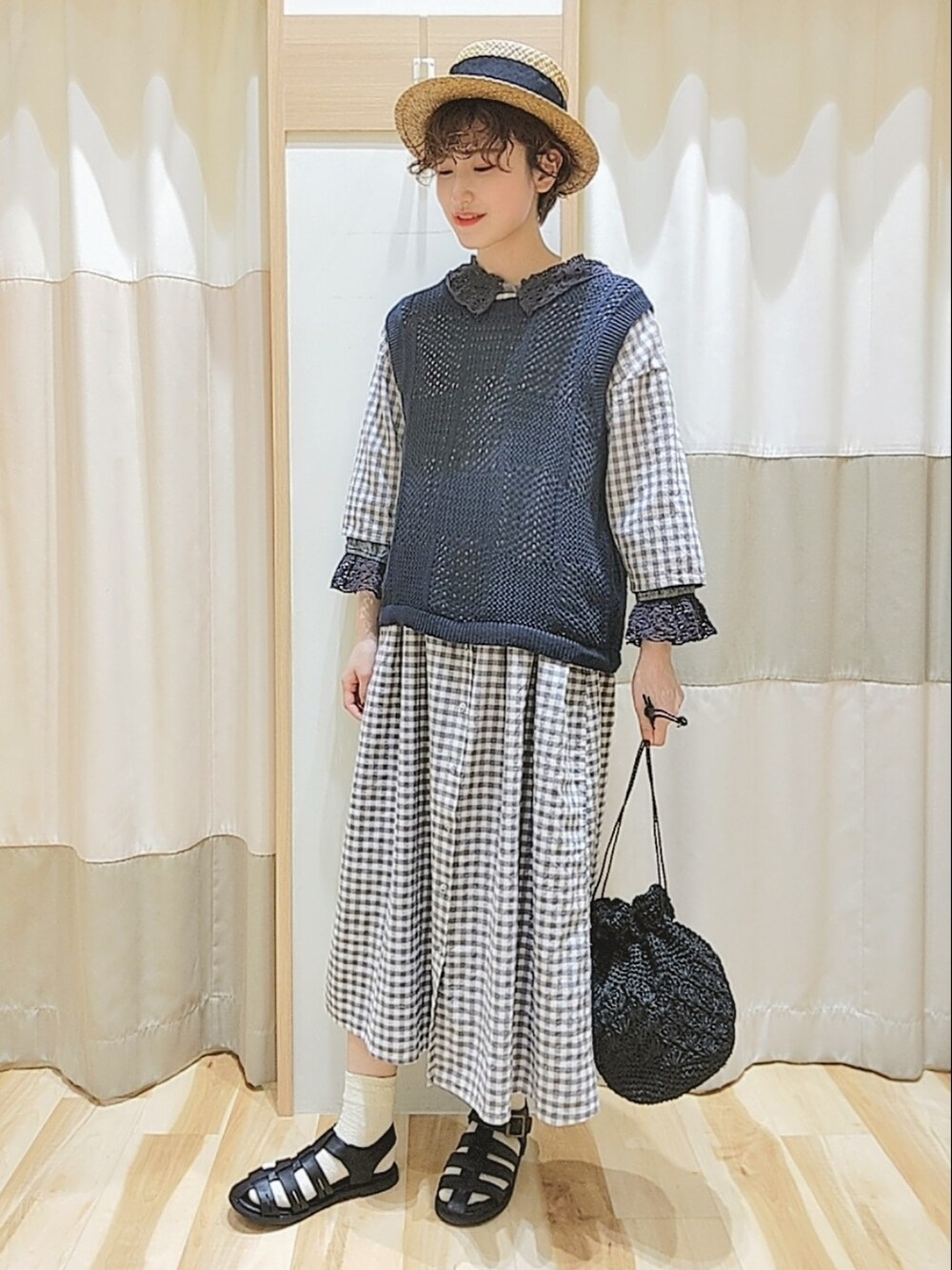 グレー系のベスト、グレー系のワンピース、ブラック系のシャツ/ブラウスを着用したレディースの春コーディネートの3枚目の写真