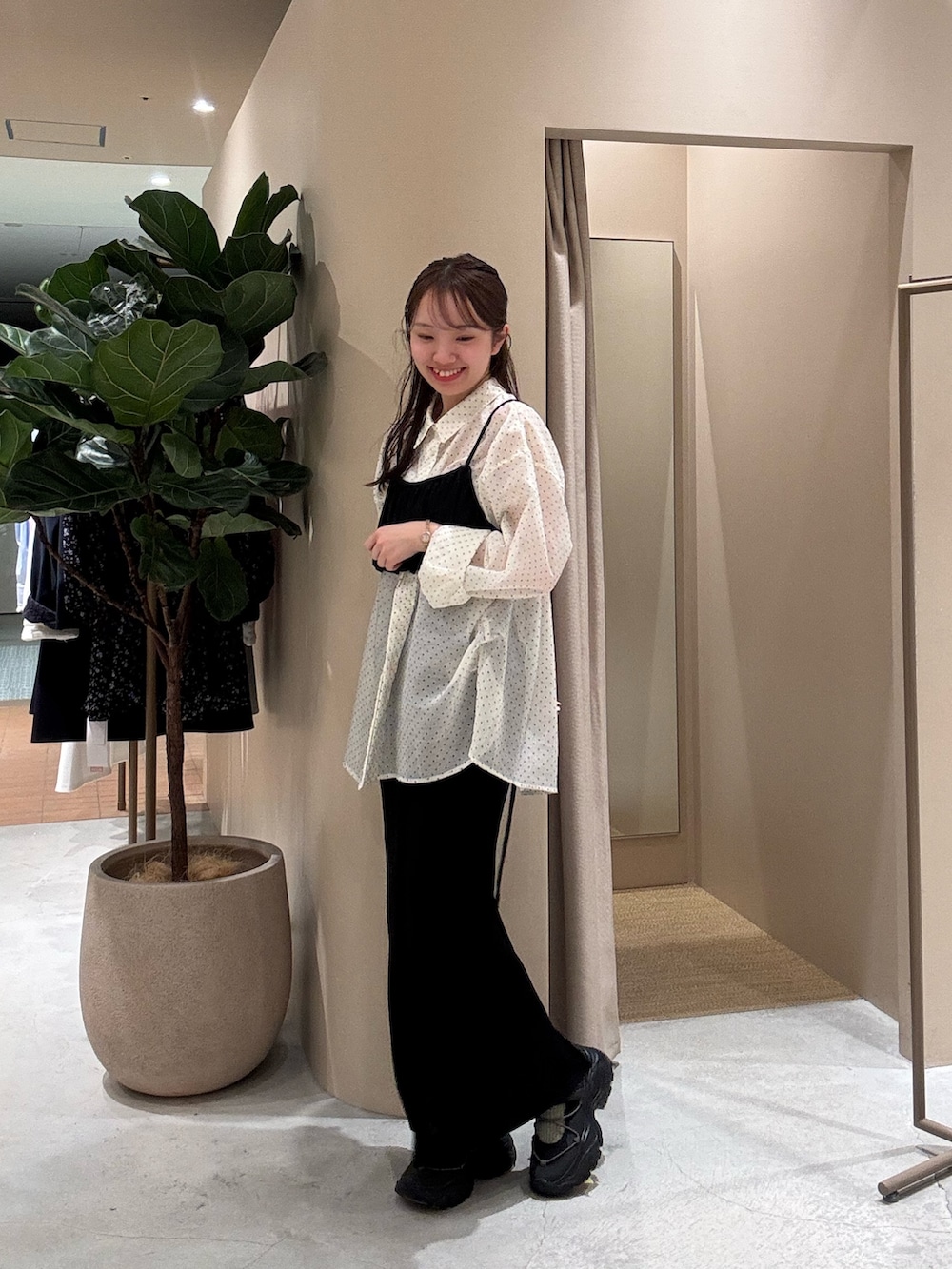 ホワイト系のシャツ/ブラウス、ブラック系のスカート、ブラック系のスニーカーを着用したレディースの春コーディネートの2枚目の写真