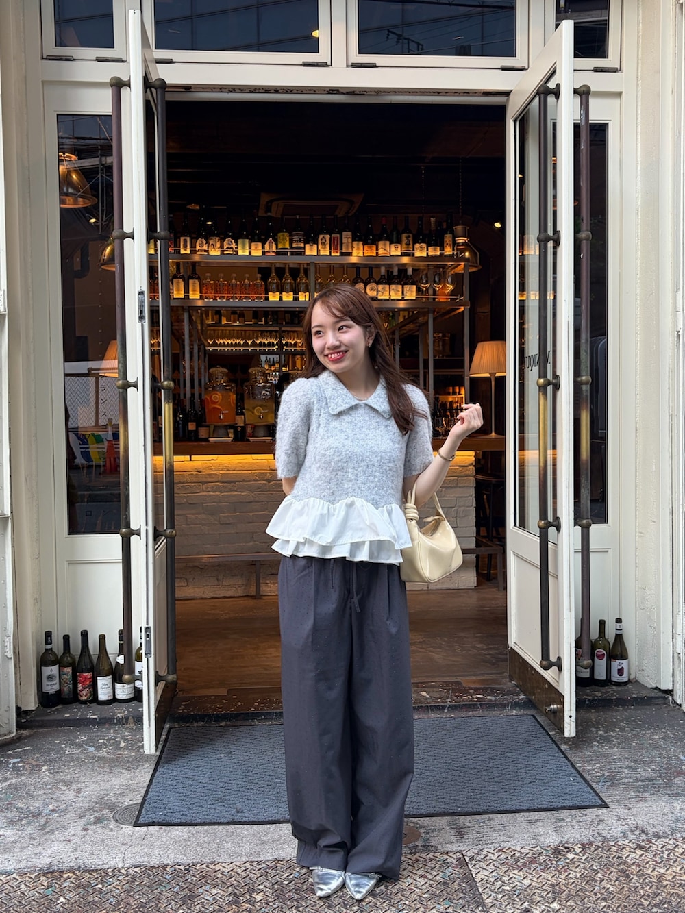 グレー系のニット/セーター、グレー系のスラックス、シルバー系のパンプスを着用したレディースの秋コーディネートの2枚目の写真