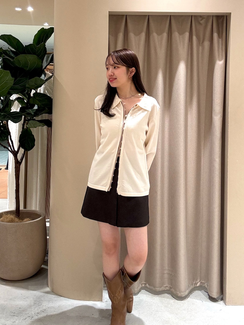 ホワイト系のカーディガン/ボレロ、ブラウン系のスカート、イエロー系のブーツを着用したレディースの春コーディネートの2枚目の写真