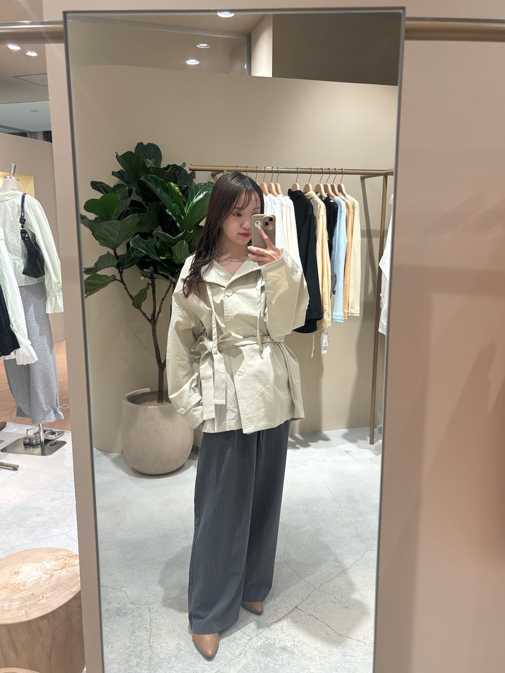 ホワイト系のトレンチコート、イエロー系のブーツを着用したレディースの春コーディネートの4枚目の写真