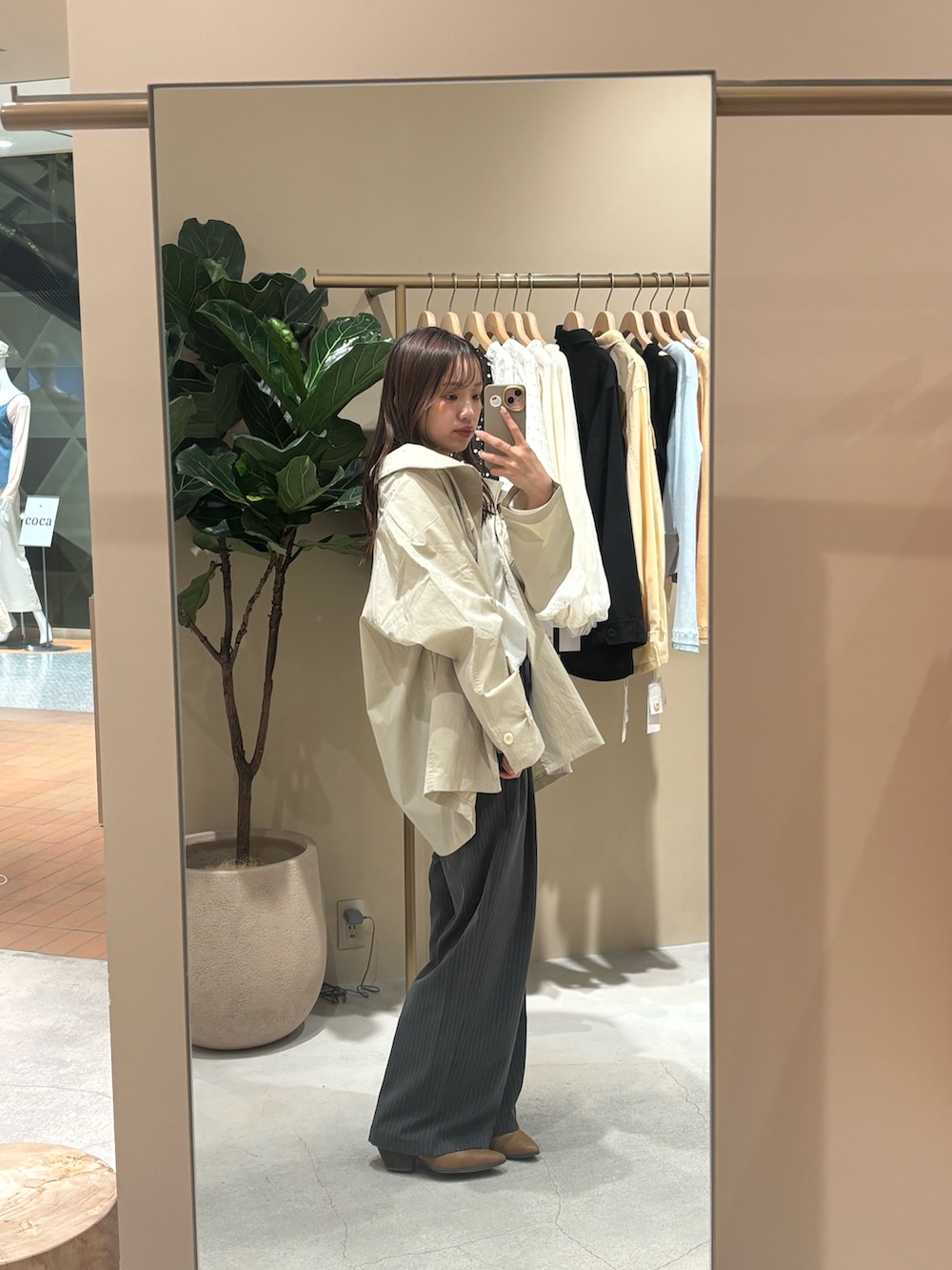 ホワイト系のトレンチコート、イエロー系のブーツを着用したレディースの春コーディネートの3枚目の写真