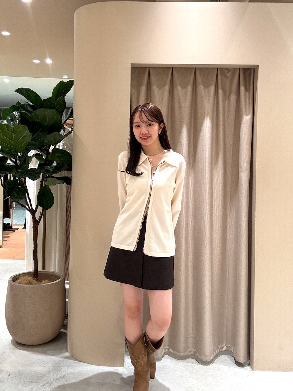 ホワイト系のカーディガン/ボレロ、ブラウン系のスカート、イエロー系のブーツを着用したレディースの春コーディネートの3枚目の写真