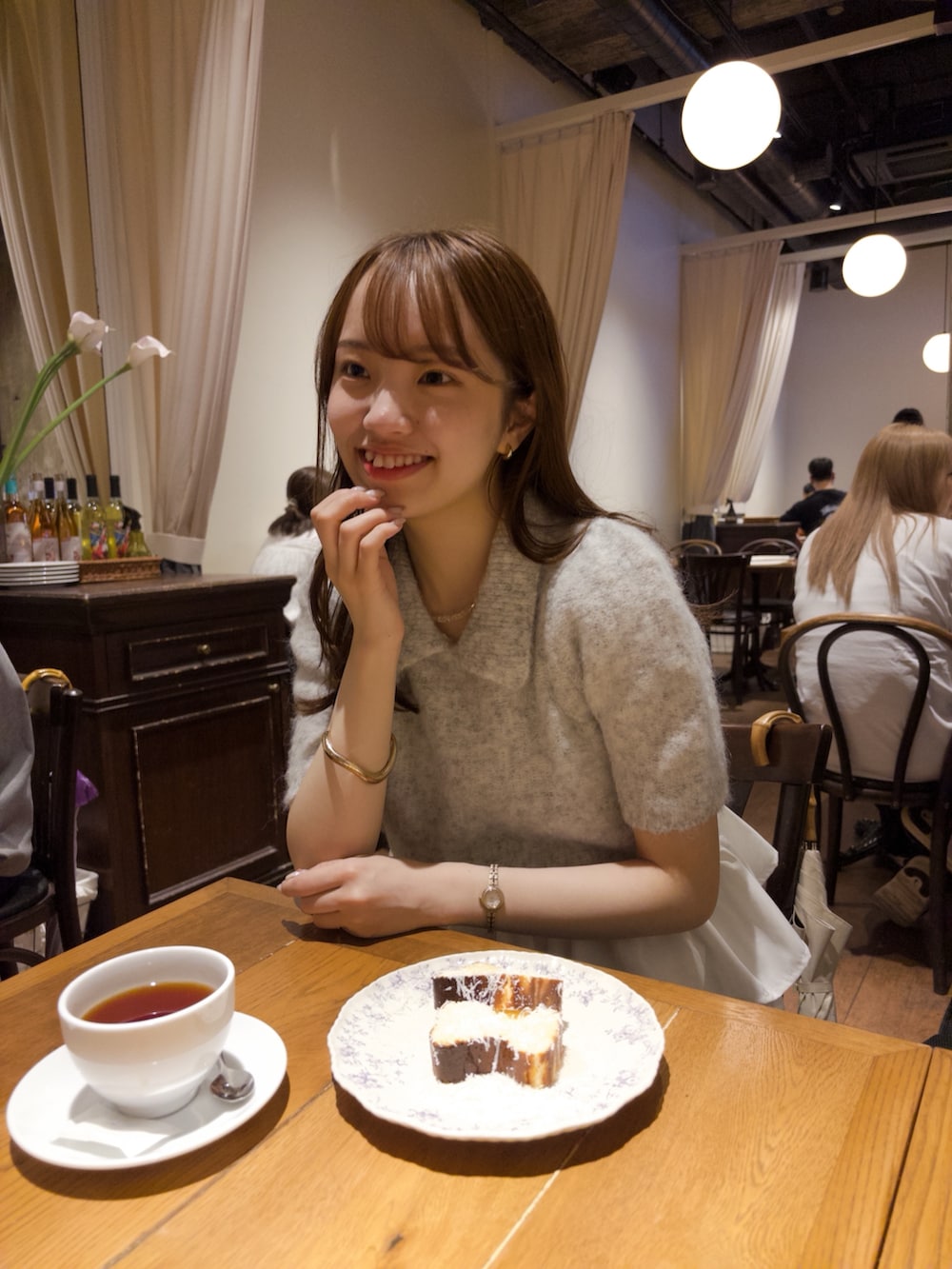 グレー系のニット/セーター、グレー系のスラックス、シルバー系のパンプスを着用したレディースの秋コーディネートの4枚目の写真