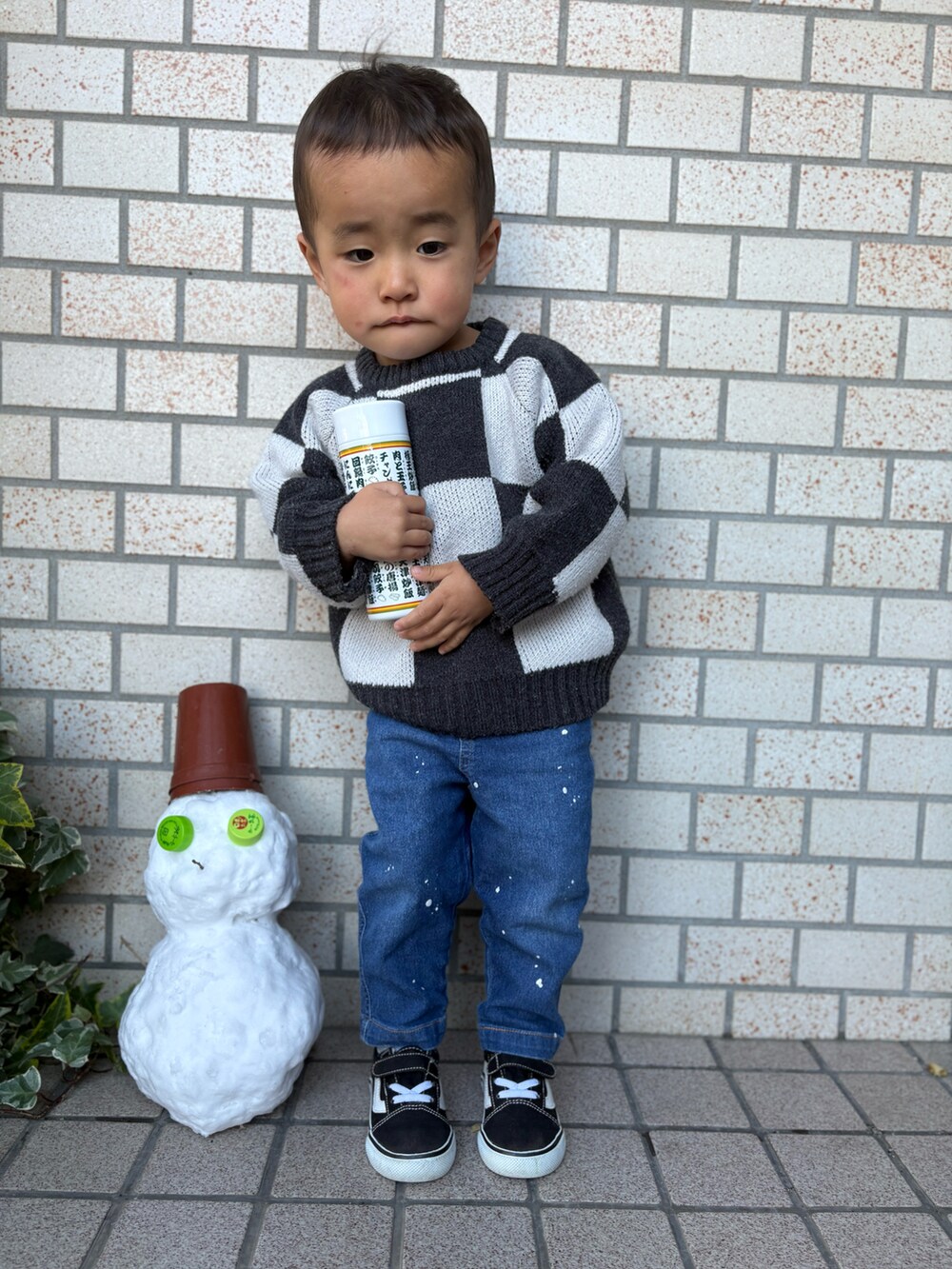 ブルー系のデニムパンツ、ブラック系のスニーカー、ブラック系のニット/セーターを着用したキッズの冬コーディネートの2枚目の写真