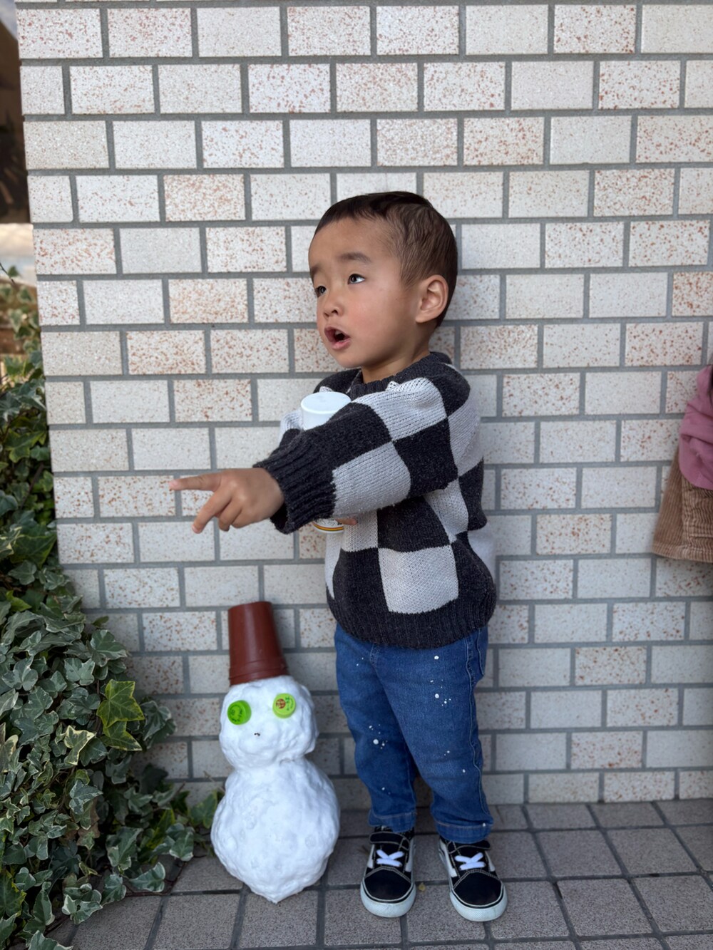 ブルー系のデニムパンツ、ブラック系のスニーカー、ブラック系のニット/セーターを着用したキッズの冬コーディネートの4枚目の写真