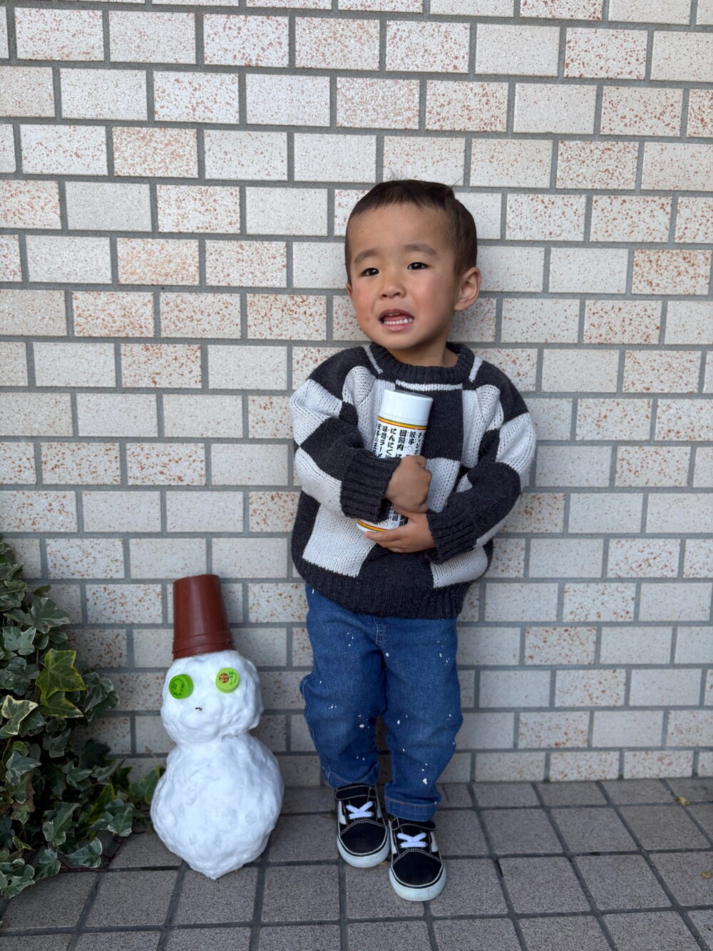 ブルー系のデニムパンツ、ブラック系のスニーカー、ブラック系のニット/セーターを着用したキッズの冬コーディネートの3枚目の写真