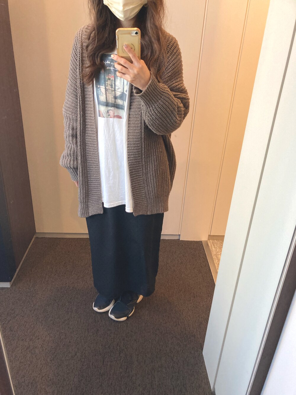 ホワイト系のTシャツ/カットソー、ブラウン系のカーディガン/ボレロ、ブラック系のスカートを着用したレディースの秋コーディネートの2枚目の写真