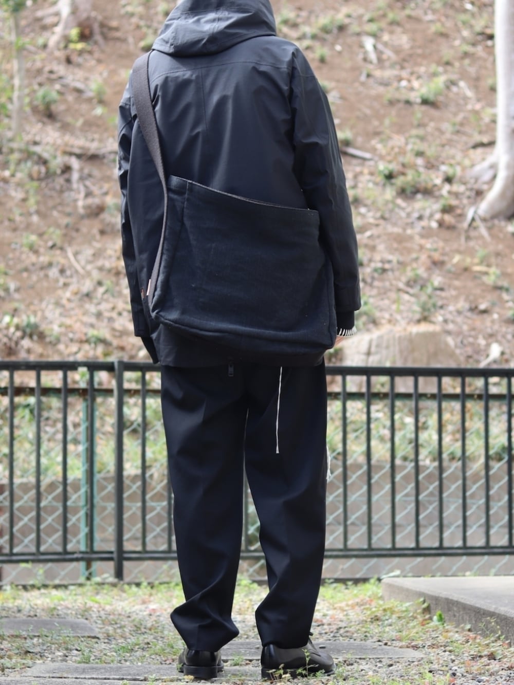 ブラック系のスラックス、ブラック系のドレスシューズ、ホワイト系のシャツ/ブラウスを着用したメンズの冬コーディネートの4枚目の写真