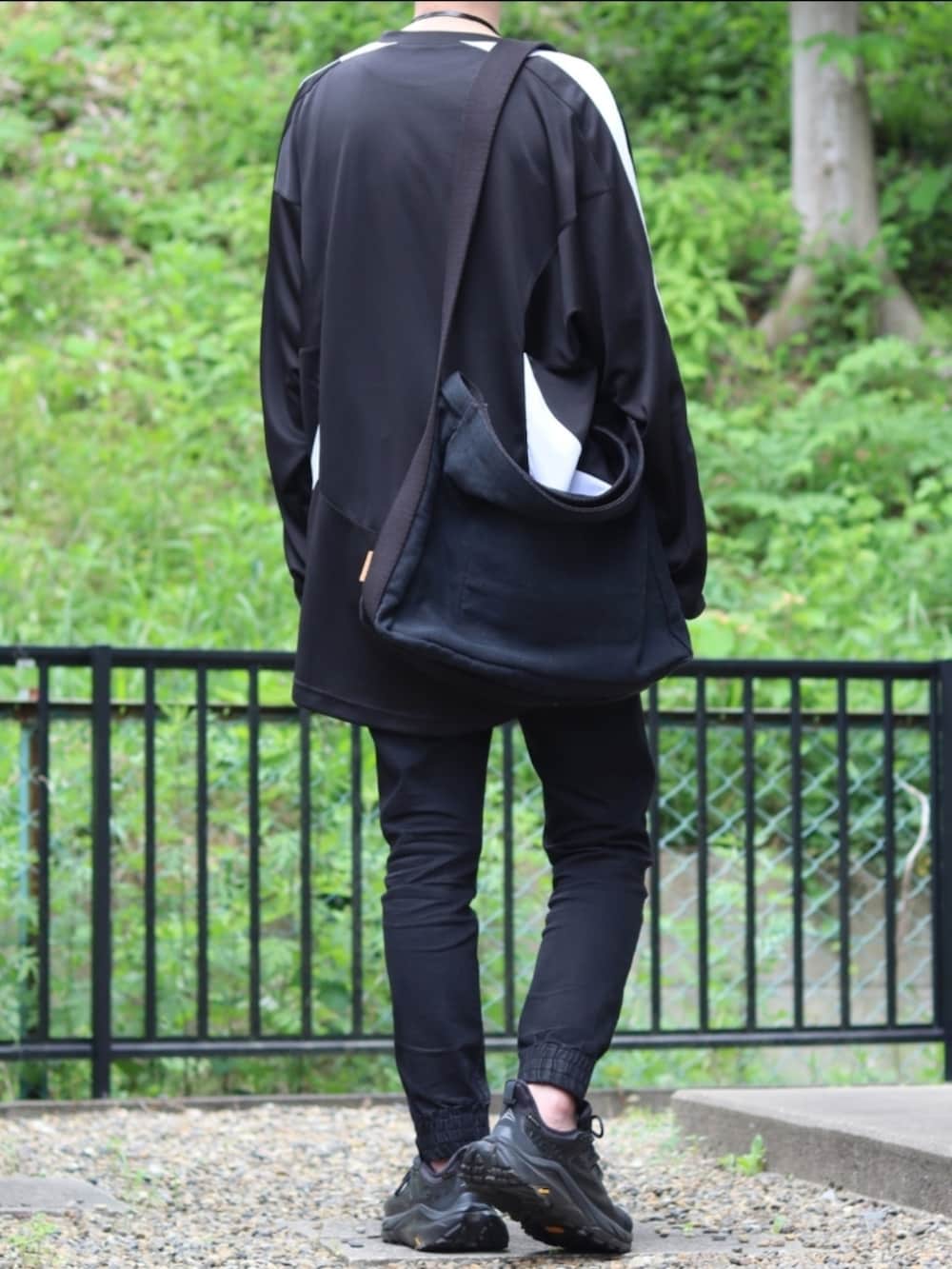 ブラック系のデニムパンツ、ブラック系のスニーカー、ブラック系のTシャツ/カットソーを着用したメンズの夏コーディネートの3枚目の写真