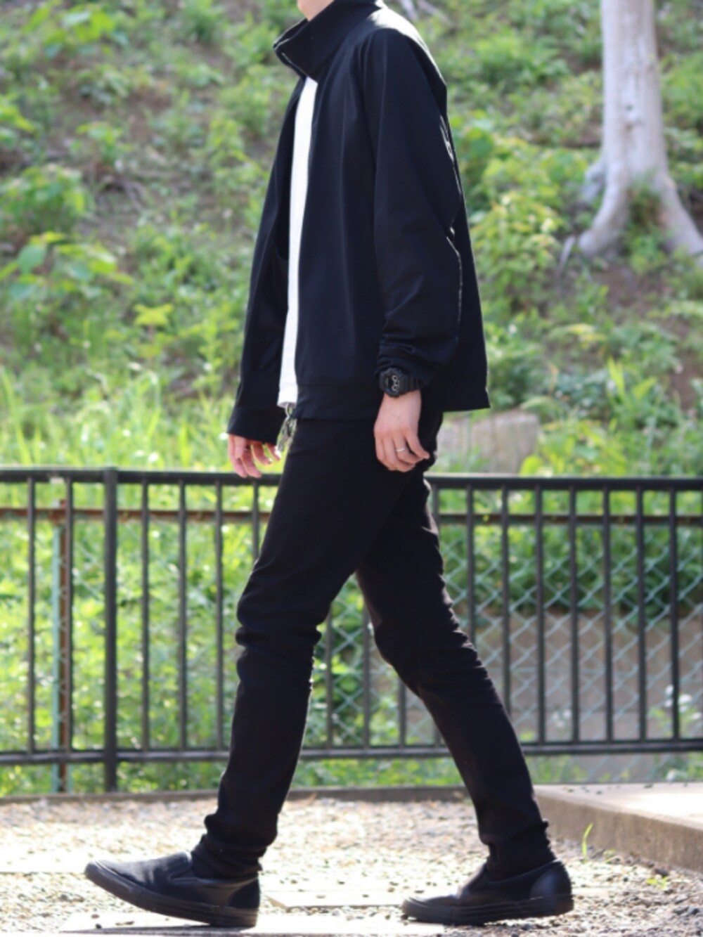 ブラック系のその他パンツ、ブラック系のその他アウター、ホワイト系のTシャツ/カットソーを着用したメンズの春コーディネートの2枚目の写真