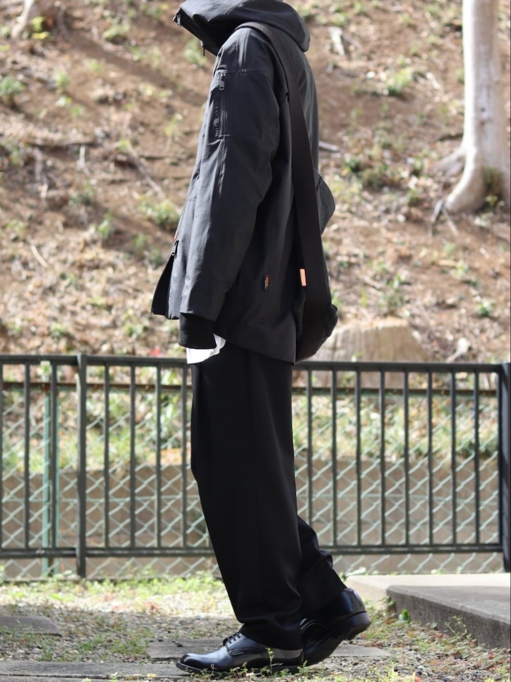 ブラック系のスラックス、ブラック系のドレスシューズ、ホワイト系のシャツ/ブラウスを着用したメンズの冬コーディネートの3枚目の写真