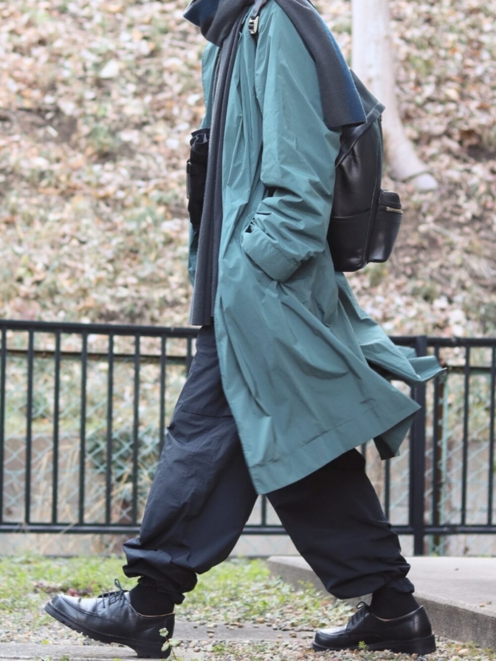 ブラック系のカーゴパンツ、グリーン系のチェスターコート、グレー系のニット/セーターを着用したメンズの冬コーディネートの2枚目の写真