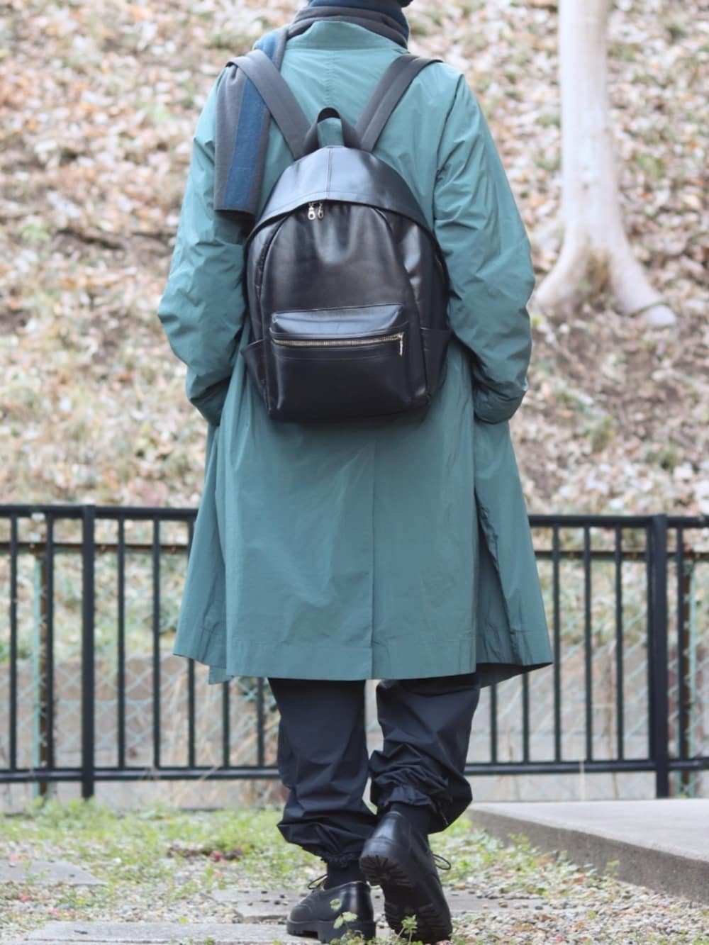 ブラック系のカーゴパンツ、グリーン系のチェスターコート、グレー系のニット/セーターを着用したメンズの冬コーディネートの3枚目の写真