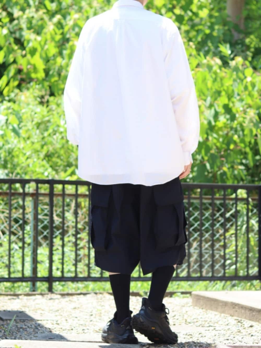 ホワイト系のシャツ/ブラウス、ブルー系のカーゴパンツ、ブラック系のスニーカーを着用したメンズの夏コーディネートの3枚目の写真