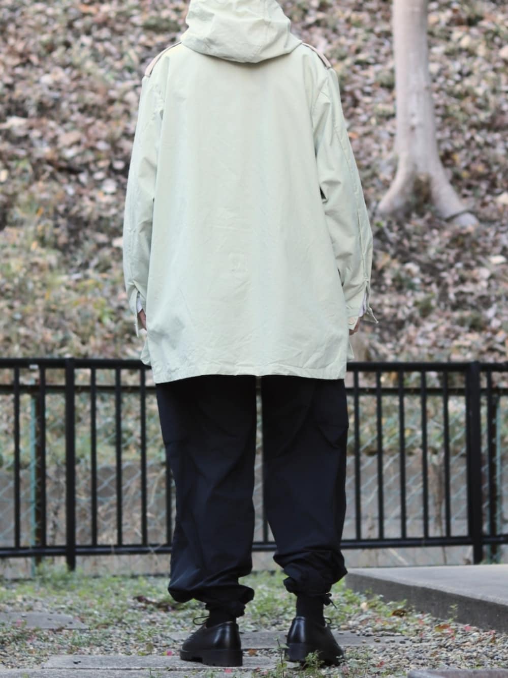 ブラック系のドレスシューズ、ホワイト系のその他アウター、ブラック系のカーゴパンツを着用したメンズの冬コーディネートの3枚目の写真