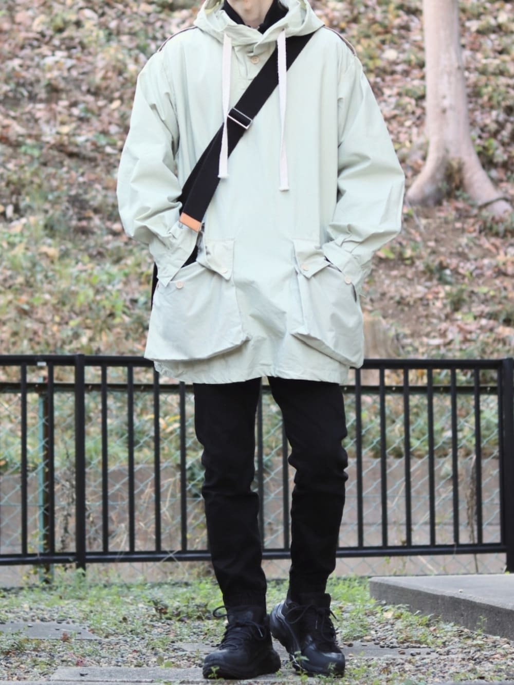 ブラック系のデニムパンツ、ホワイト系のその他アウター、ブラック系のスニーカーを着用したメンズの冬コーディネートの2枚目の写真