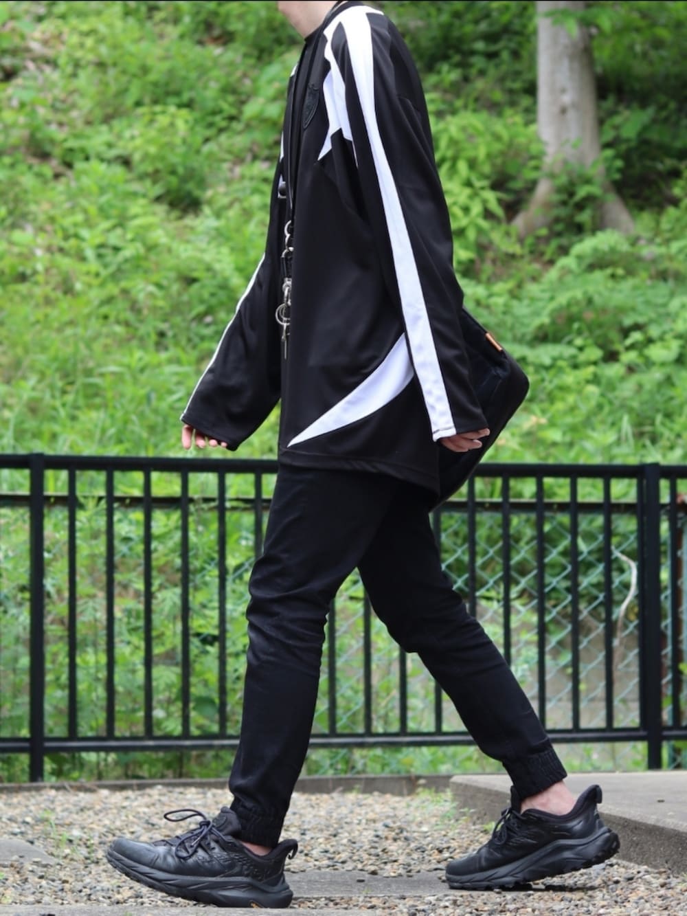 ブラック系のデニムパンツ、ブラック系のスニーカー、ブラック系のTシャツ/カットソーを着用したメンズの夏コーディネートの2枚目の写真