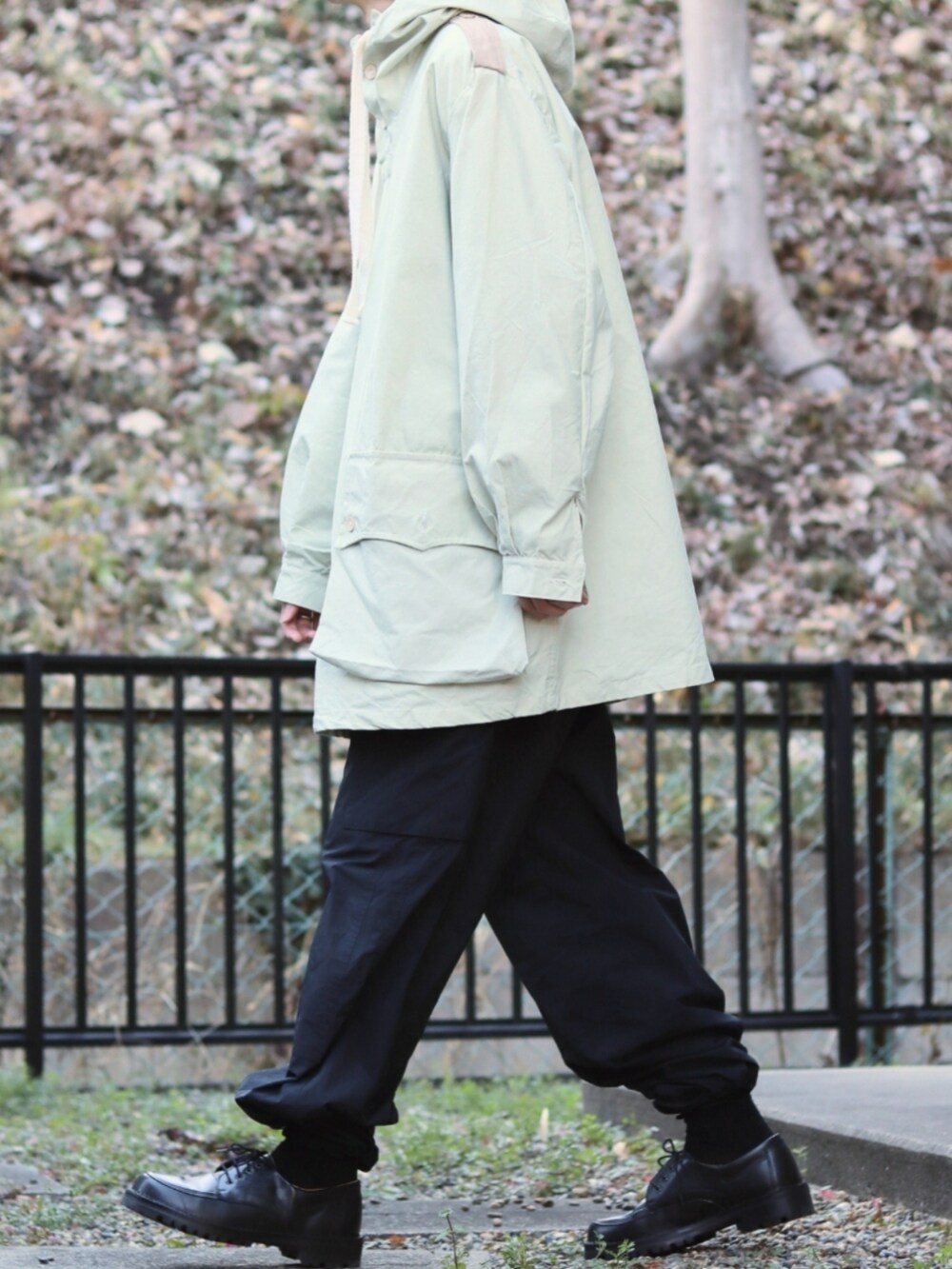 ブラック系のドレスシューズ、ホワイト系のその他アウター、ブラック系のカーゴパンツを着用したメンズの冬コーディネートの2枚目の写真