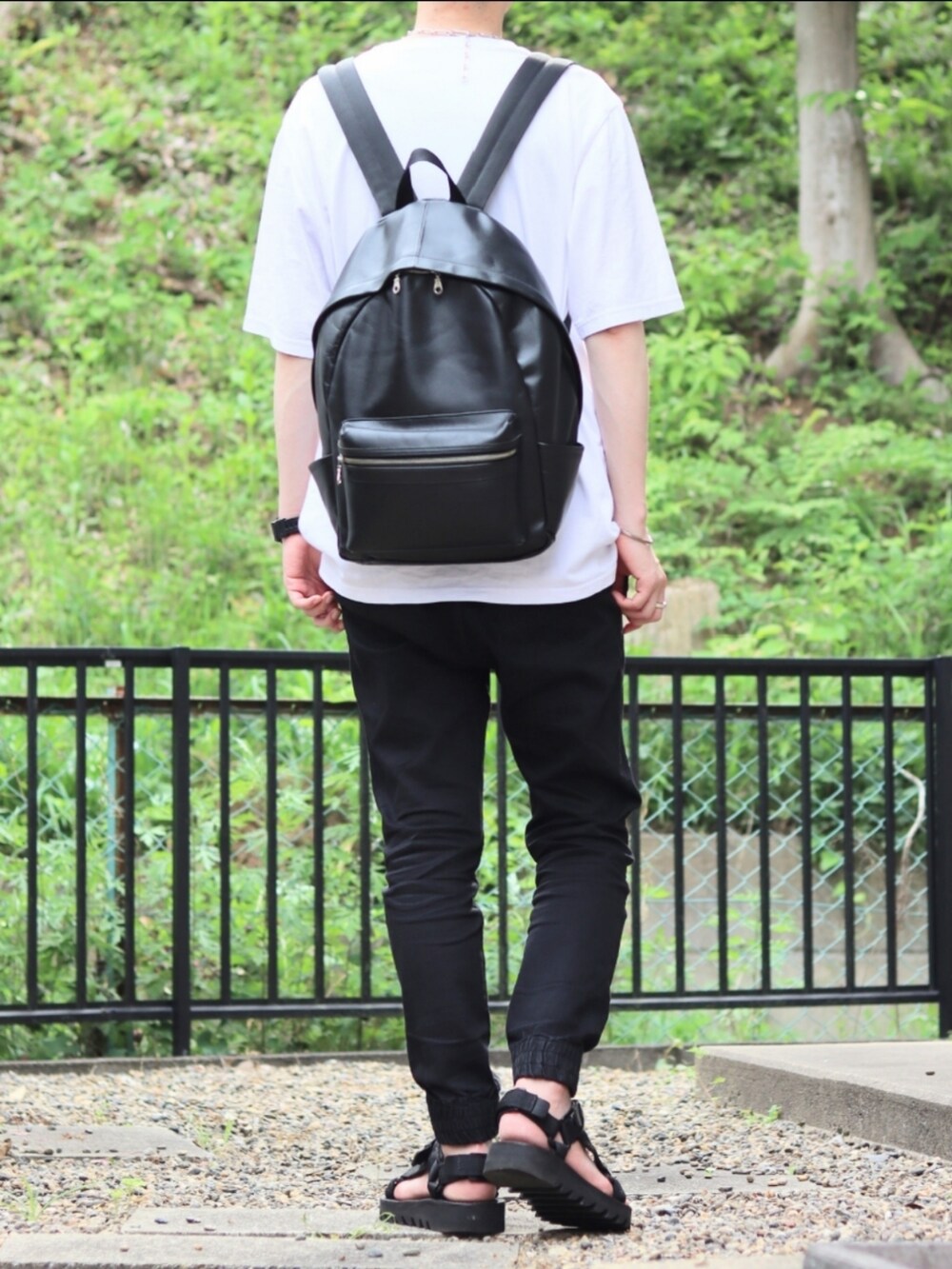 ブラック系のデニムパンツ、ブラック系のその他シューズ、ホワイト系のTシャツ/カットソーを着用したメンズの夏コーディネートの3枚目の写真