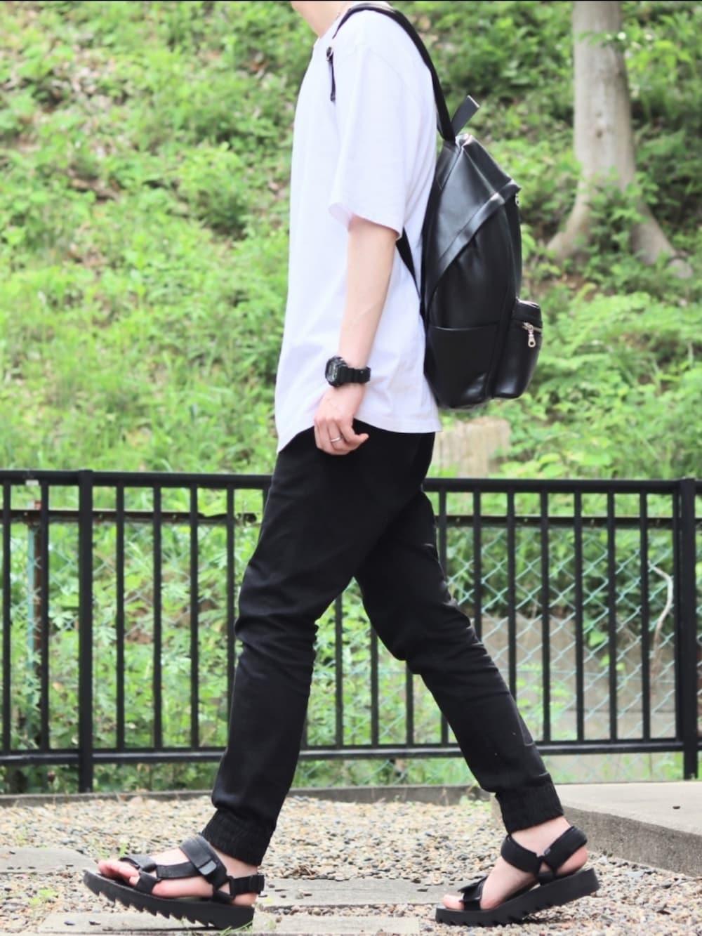 ブラック系のデニムパンツ、ブラック系のその他シューズ、ホワイト系のTシャツ/カットソーを着用したメンズの夏コーディネートの2枚目の写真