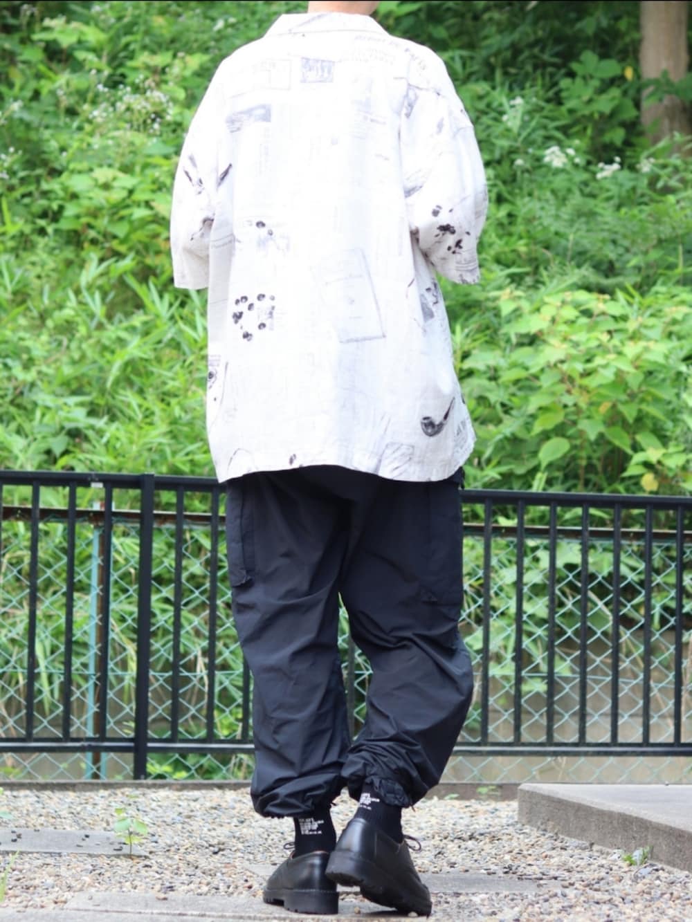 ブラック系のカーゴパンツ、ブラック系のドレスシューズ、ホワイト系のシャツ/ブラウスを着用したメンズの夏コーディネートの3枚目の写真