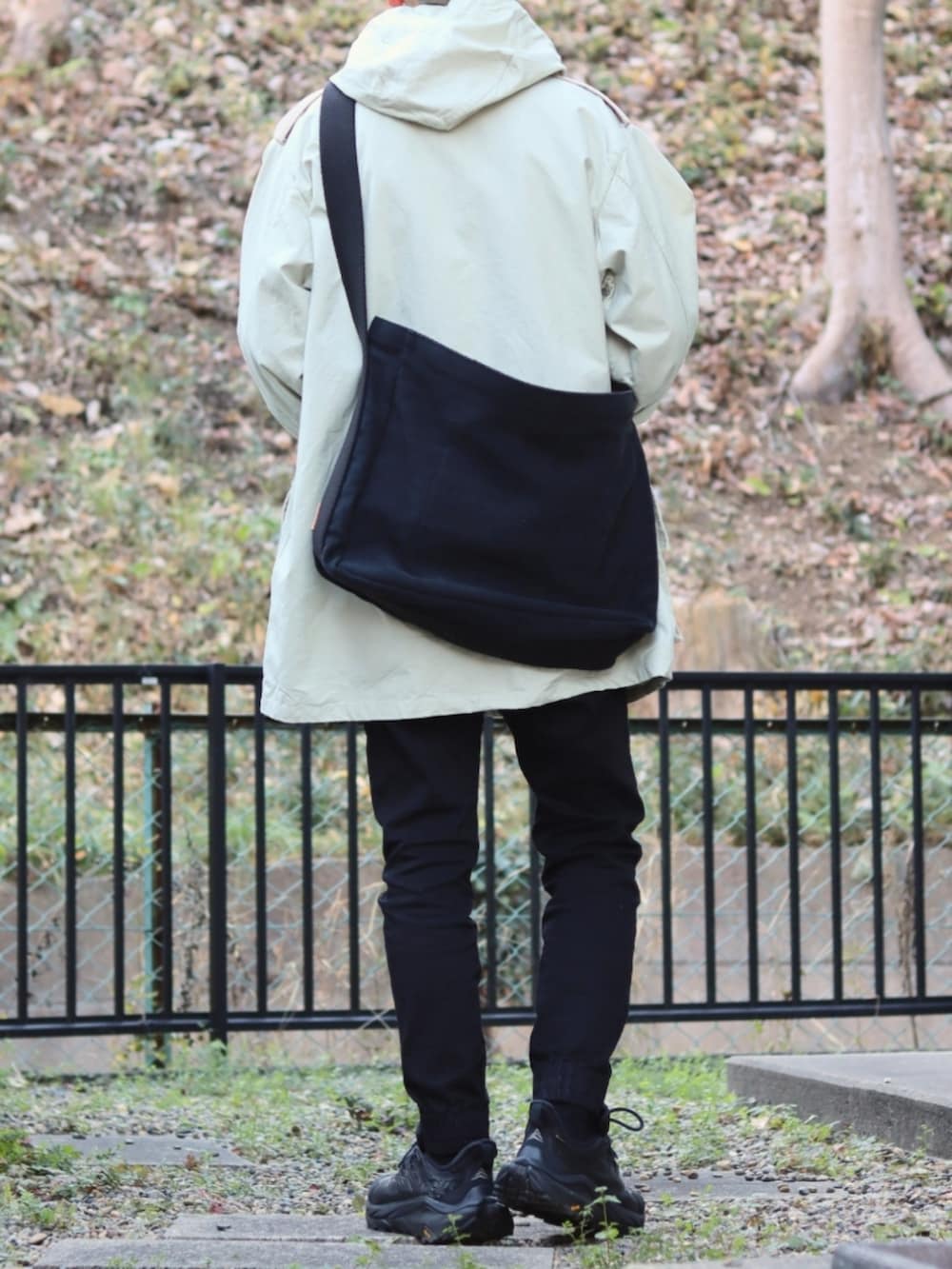 ブラック系のデニムパンツ、ホワイト系のその他アウター、ブラック系のスニーカーを着用したメンズの冬コーディネートの4枚目の写真