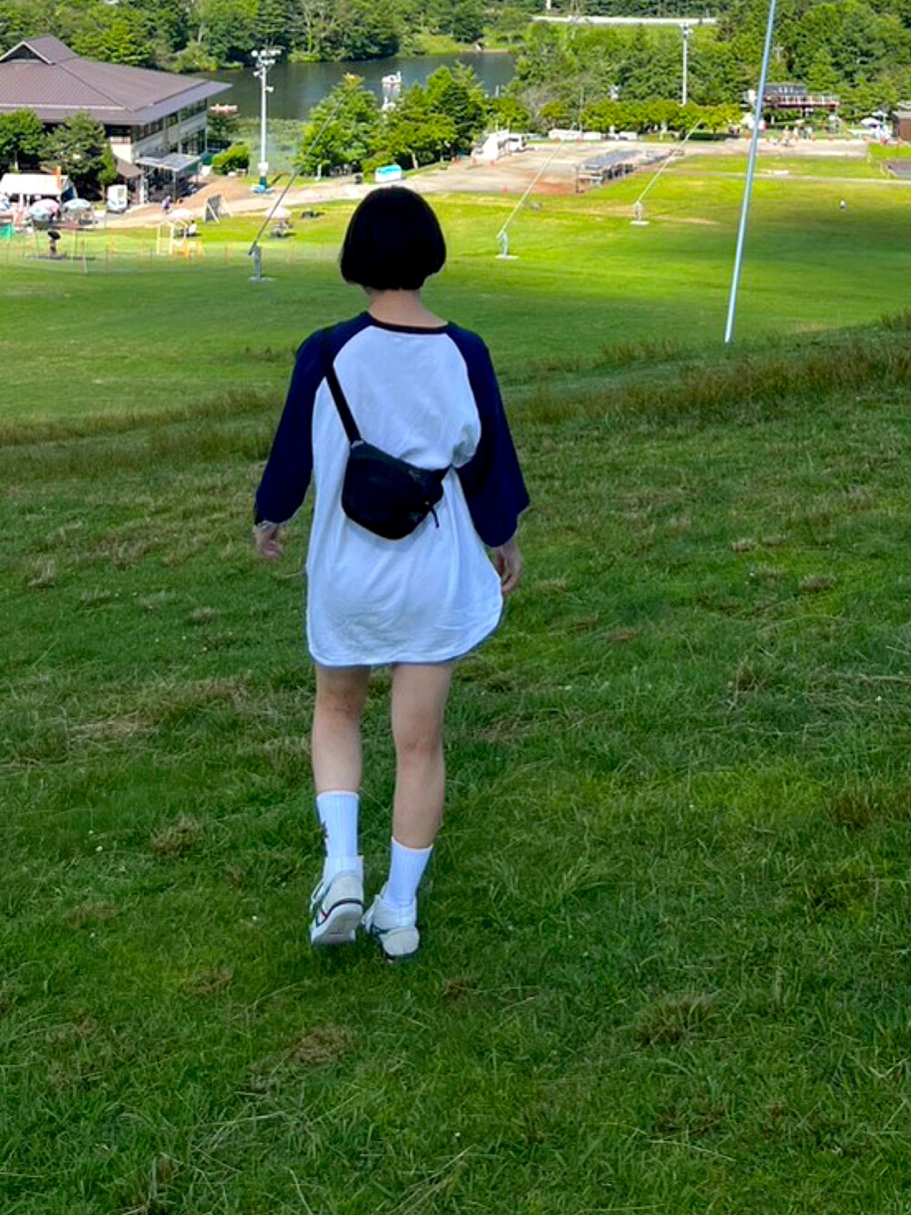 ホワイト系のスニーカー、ブラック系のサングラス、ブラック系の腕時計を着用したレディースの夏コーディネートの2枚目の写真