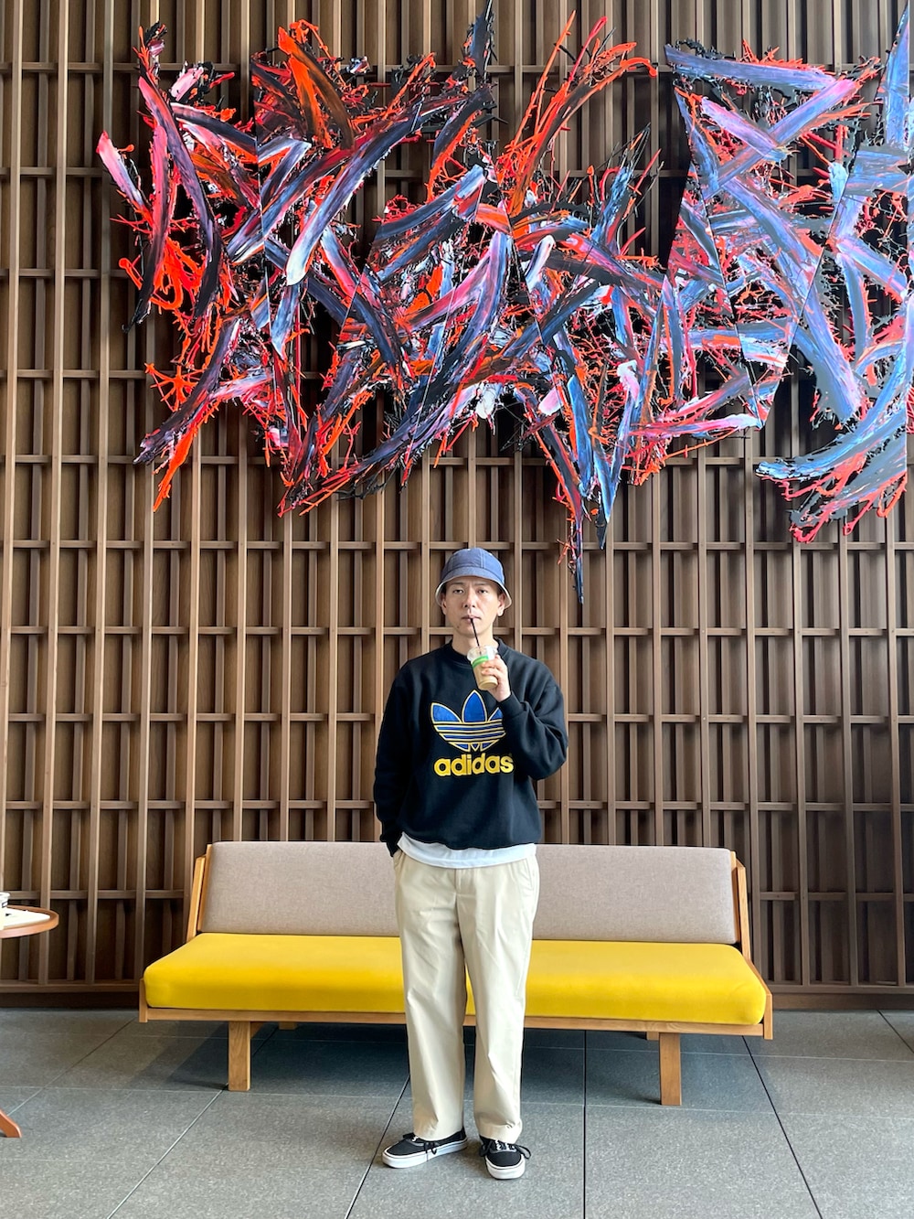 ブラック系のスウェット、ベージュ系のチノパンツ、ブラック系のスニーカーを着用したメンズの春コーディネートの2枚目の写真