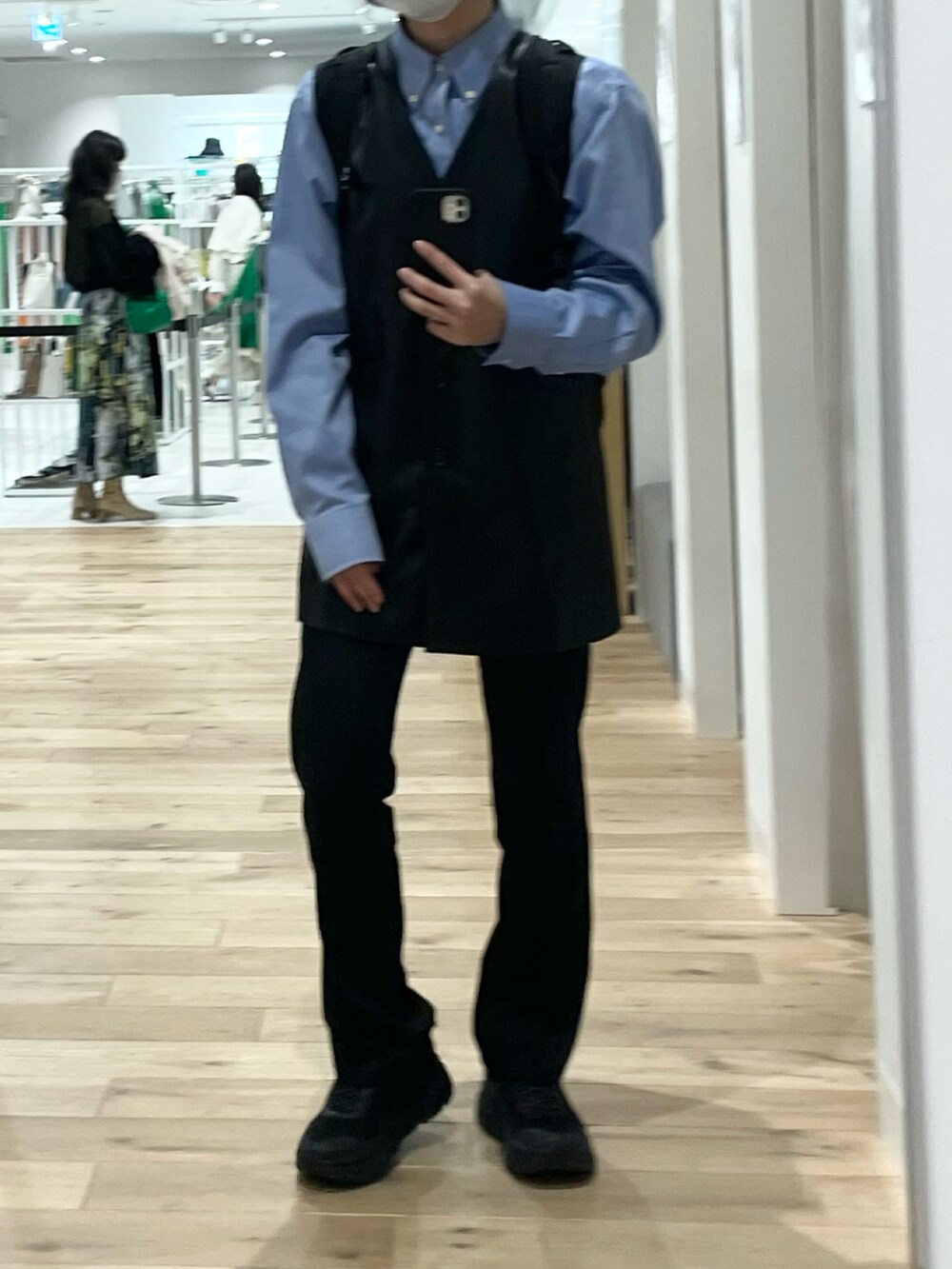 ブラック系のベスト、ブラック系のスラックス、ブラック系のスニーカーを着用したレディースの春コーディネートの2枚目の写真