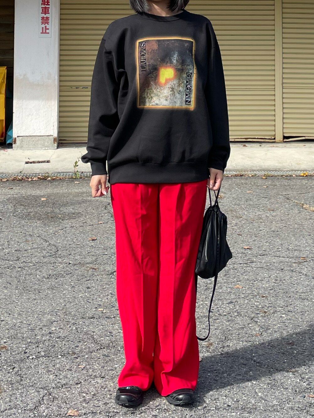 グレー系のスウェット、レッド系のスラックス、ブラック系のスニーカーを着用したレディースの秋コーディネートの2枚目の写真