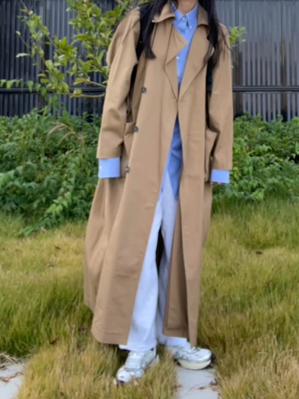 ベージュ系のトレンチコート、ブルー系のシャツ/ブラウス、グレー系のスウェットパンツを着用したレディースの秋コーディネートの2枚目の写真