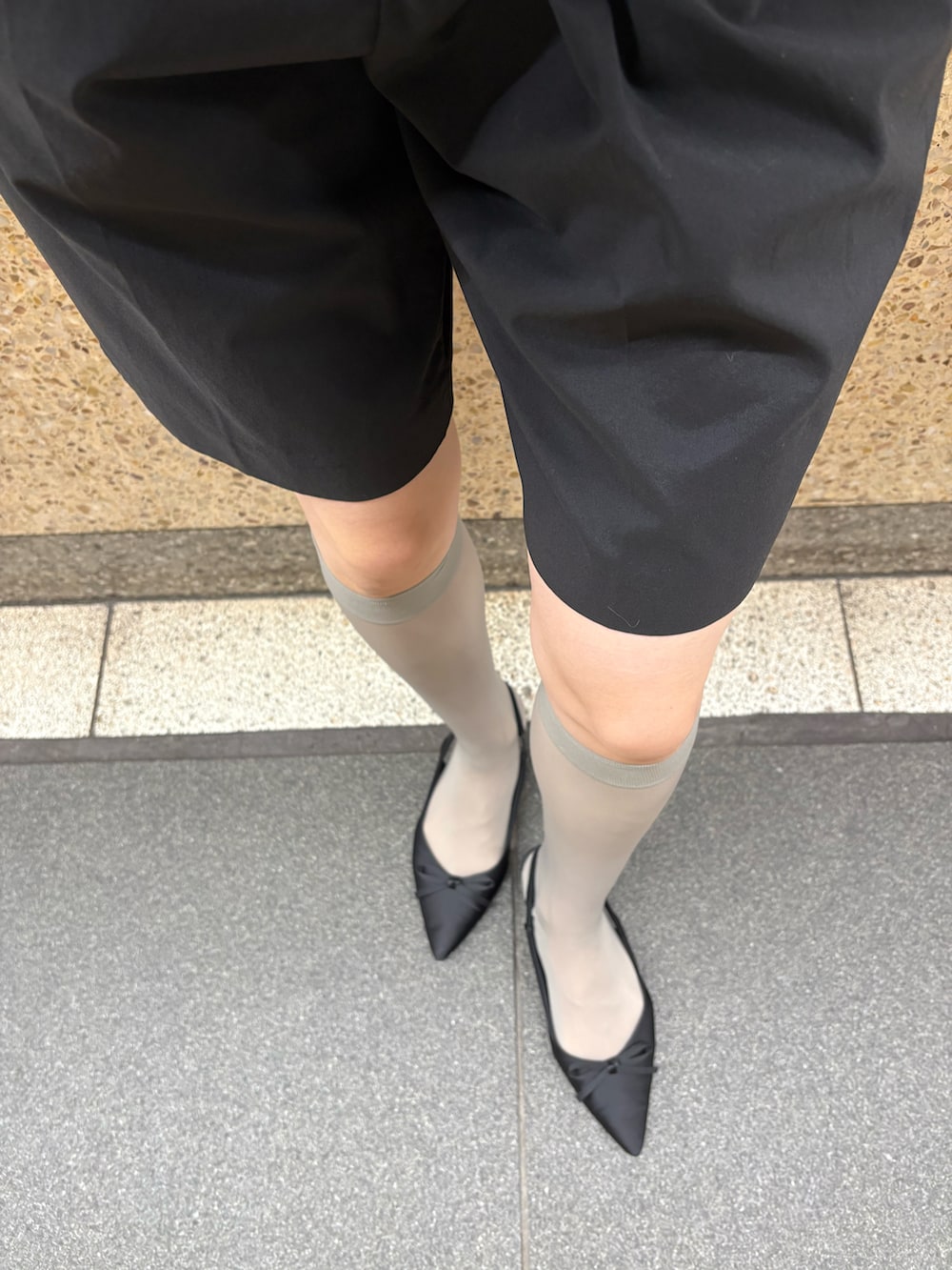 グレー系のスウェット、ブラック系のパンツ、ブラック系のドレスシューズを着用したレディースの秋コーディネートの3枚目の写真