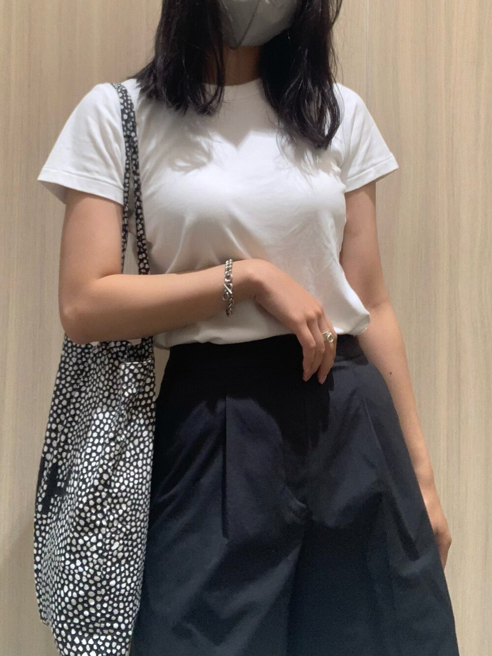 ブラック系のパンツ、ブラック系のサンダル、ブラック系のトートバッグを着用したレディースの夏コーディネートの2枚目の写真