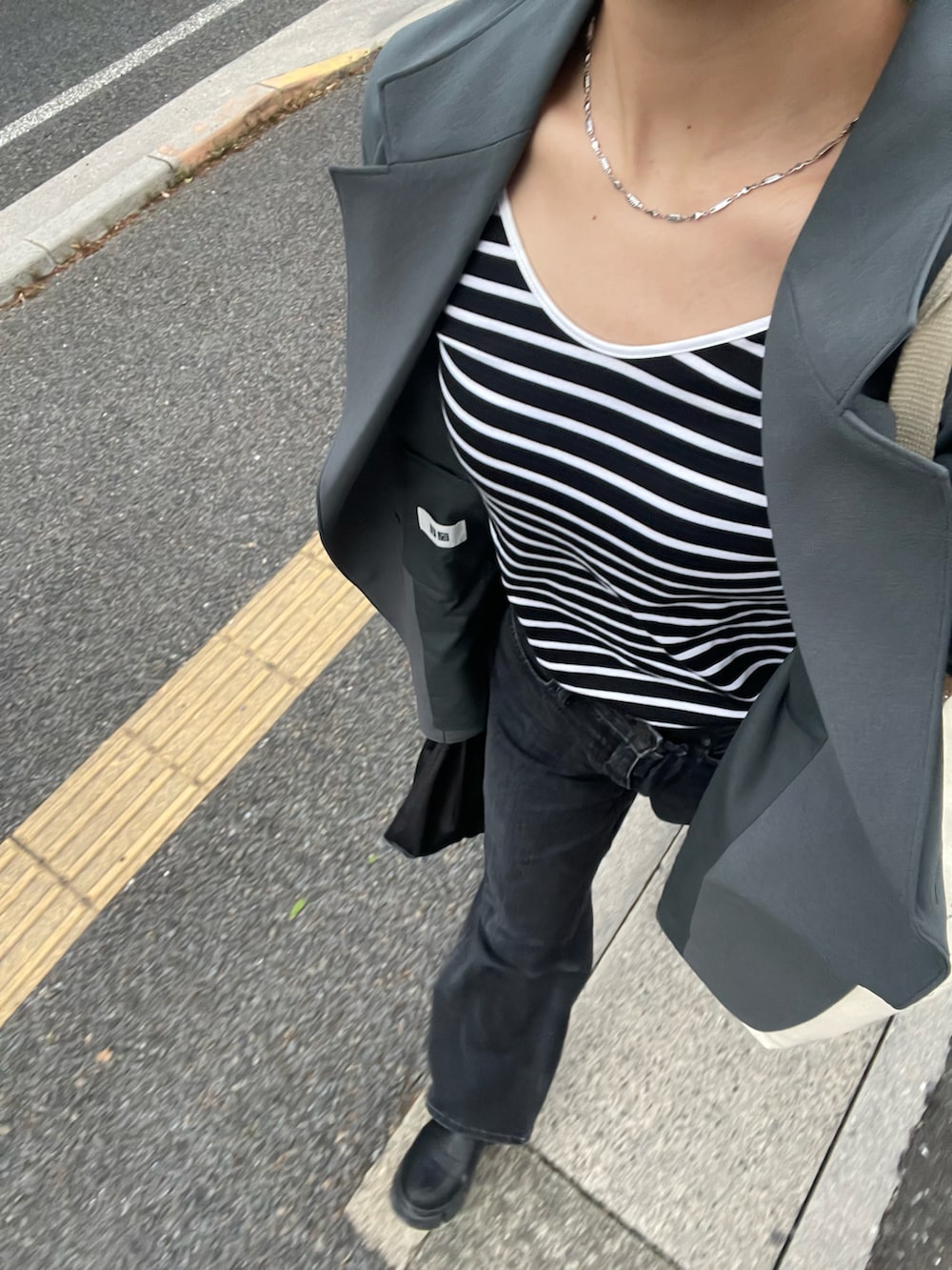 ブラック系のTシャツ/カットソー、グリーン系のテーラードジャケット、ブラック系のバッグを着用したレディースの春コーディネートの2枚目の写真